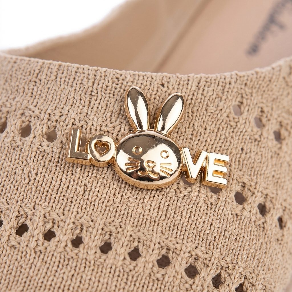 Деталь золотистої LOVE Bunny-бляшки на бежевих мюлі Nuovera Breeze